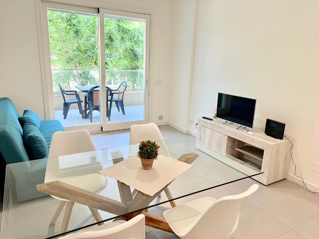 uma sala de estar com uma mesa e cadeiras e uma televisão em Alghero CHARMING APARTMENTS DOWNTOWN em Alghero