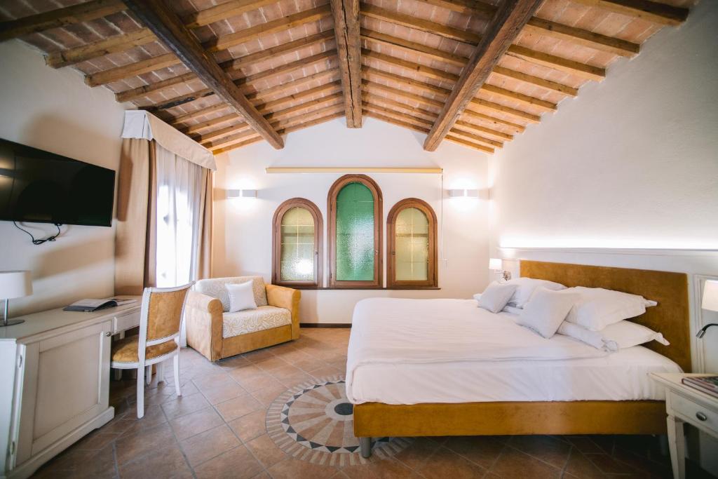 a bedroom with a bed and a desk and a chair at BACCO D'ORO Wine & Relais in Mezzane di Sotto