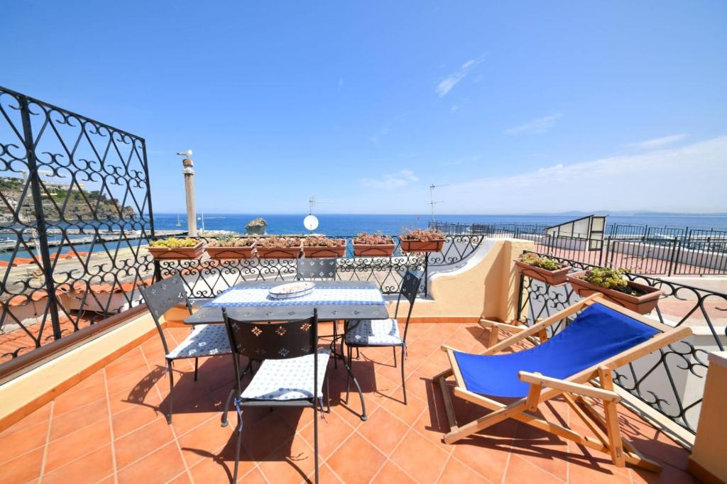 a balcony with a table and chairs and the ocean at A' casa 'e Carmeniello in Ischia