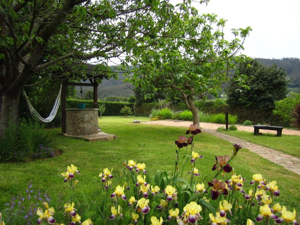 un jardín con flores en la hierba en As Jarras en Cedeira