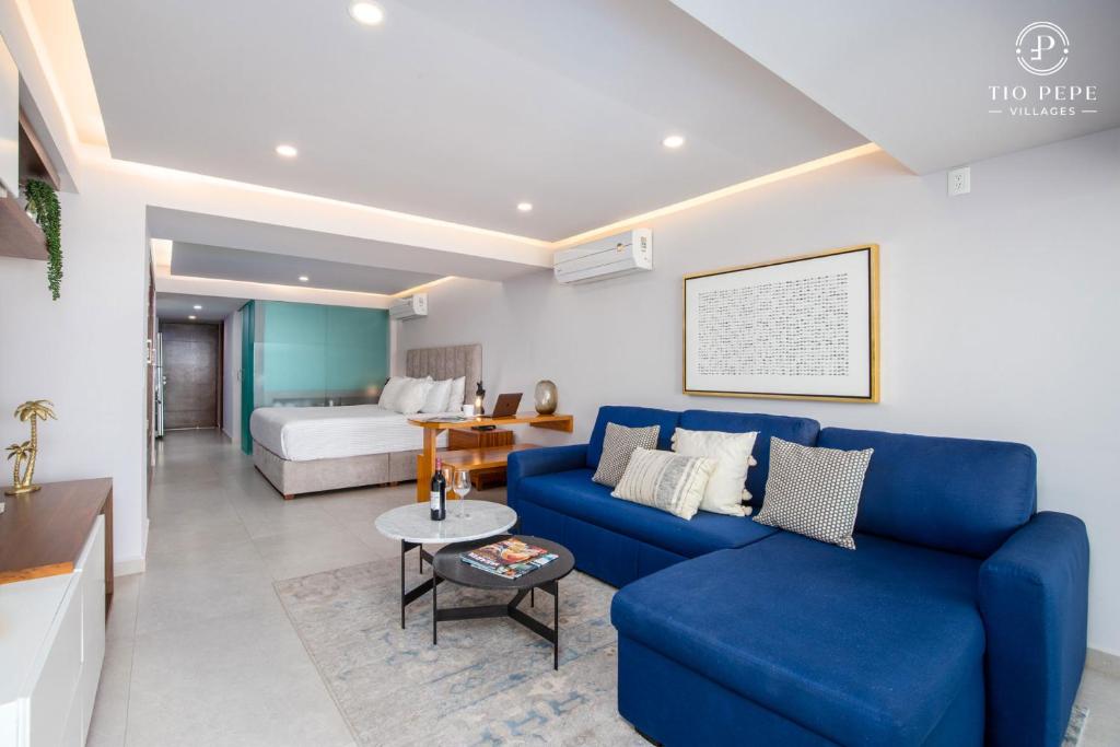a living room with a blue couch and a bed at Harbor Puerto Vallarta 5009 in Puerto Vallarta