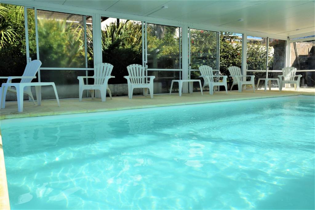 a group of chairs and a swimming pool at Apart Hotel Terrazas de San Francisco in Piriápolis