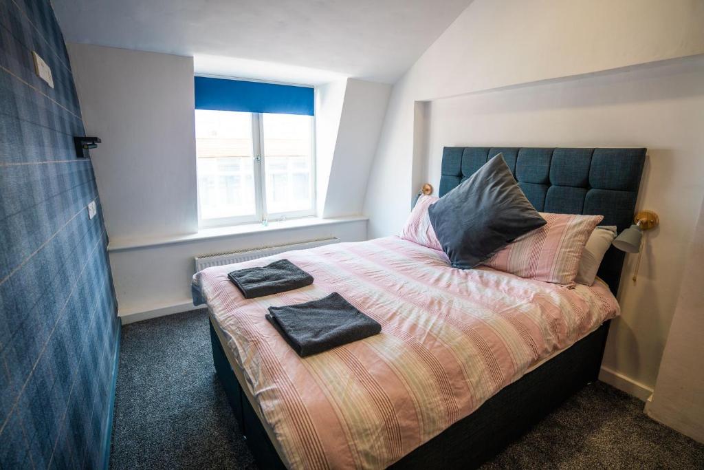 1 dormitorio con 1 cama con 2 toallas en Apartment Chinatown 303, en Newcastle