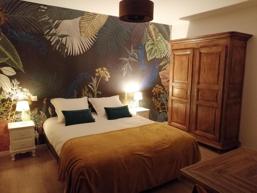 - une chambre avec un lit et un mur orné de plantes dans l'établissement Le Domaine de Pivette, à Avranches