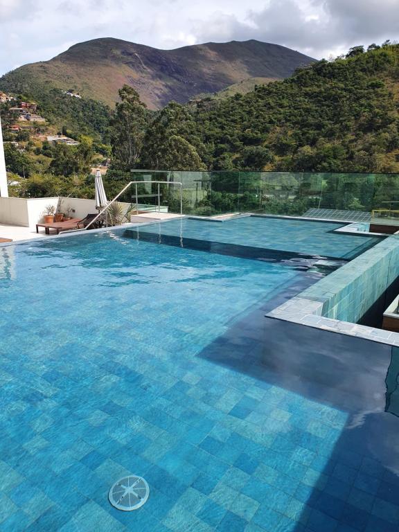 uma piscina com uma montanha ao fundo em Casa Villa Constanza em Itaipava