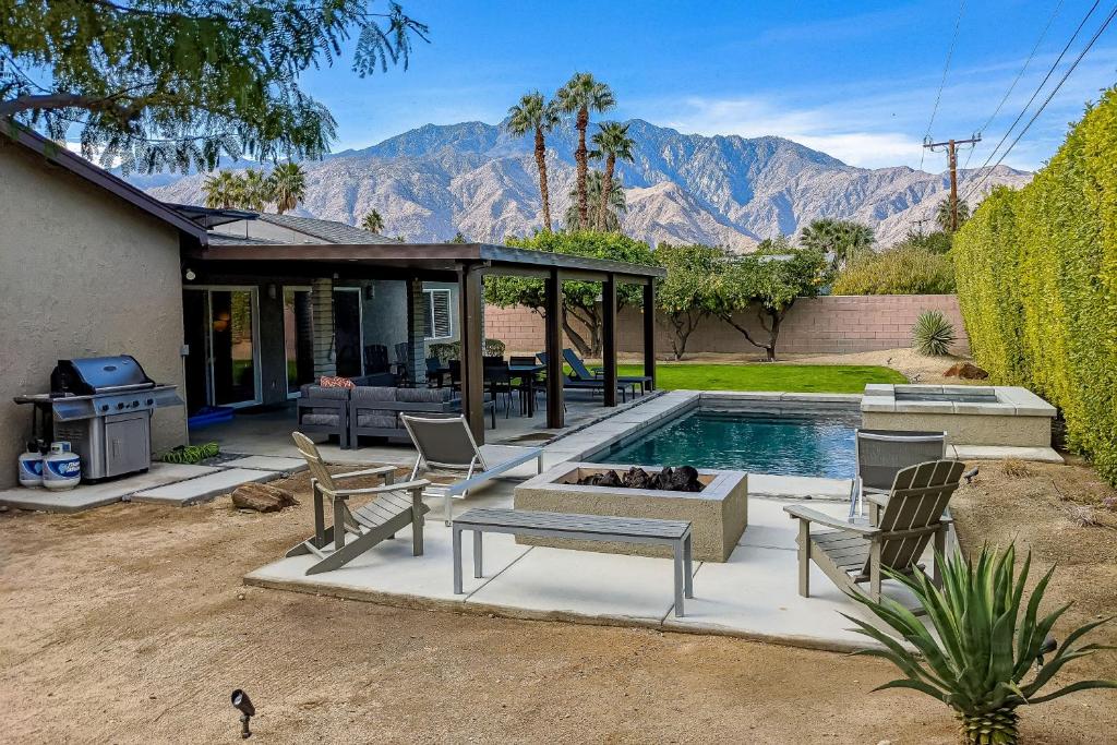 een achtertuin met een zwembad en een huis met een vuurplaats bij Palm Springs Modern Home Permit# 3972 in Palm Springs