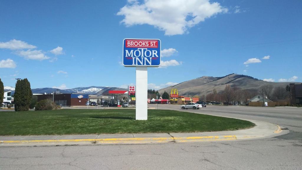 um sinal para uma estalagem na berma de uma estrada em Brooks St. Motor Inn em Missoula