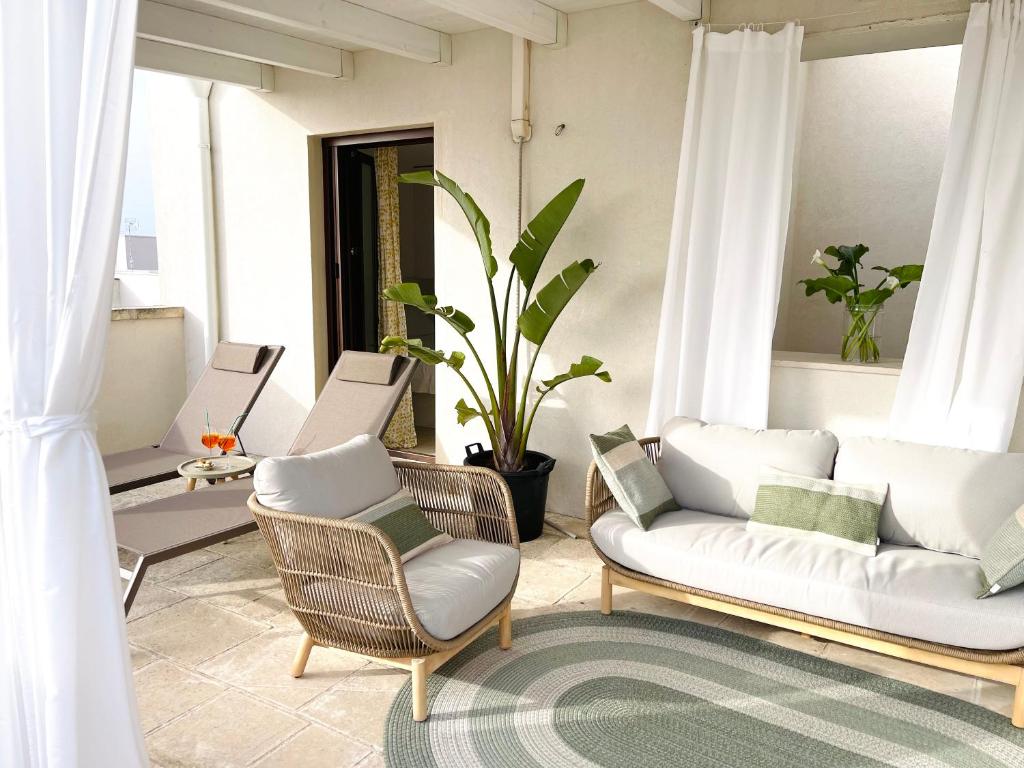 sala de estar con 2 sillas y sofá en Ideal Rooms, en Porto Cesareo