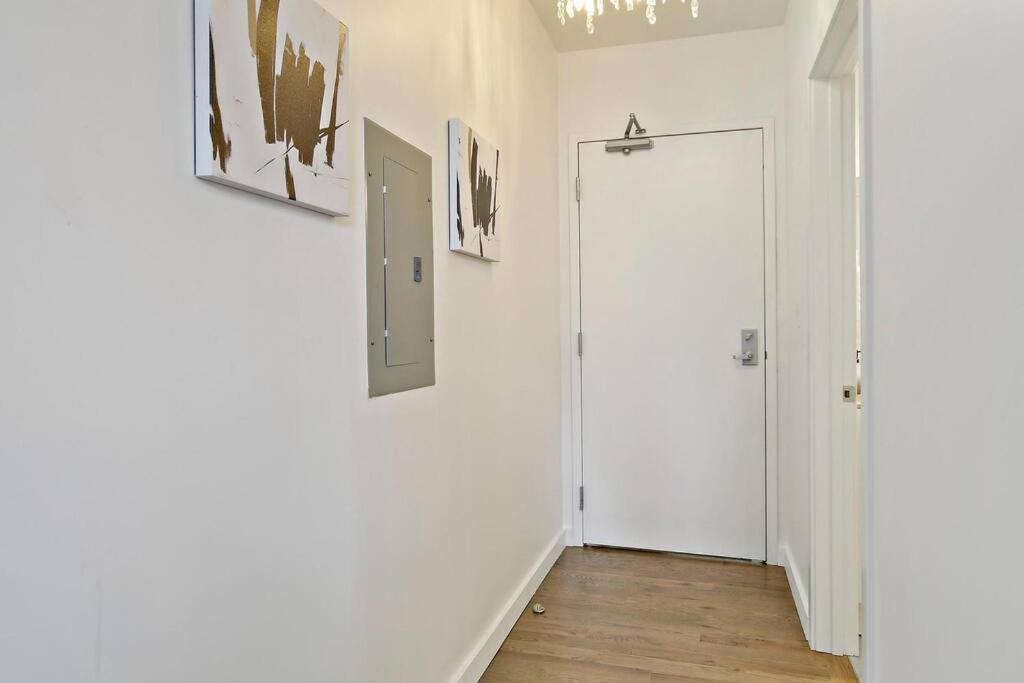 un pasillo con paredes blancas, una puerta y pinturas en 1BR Peaceful & Complete Apt with In-unit Laundry - Lake 303 en Chicago