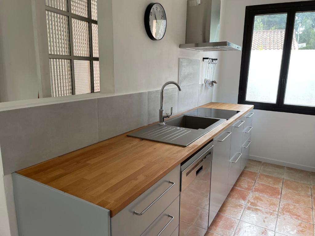 a kitchen with a sink and a wooden counter top at Appartement spacieux et lumineux Calanques Sormiou in Marseille