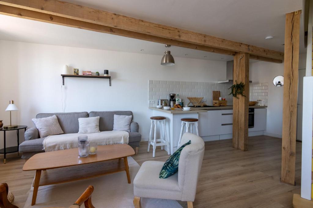 a living room with a couch and a table at APPARTEMENT DUPLEX SAUMUR CENTRE, refait à neuf, à proximité du château in Saumur