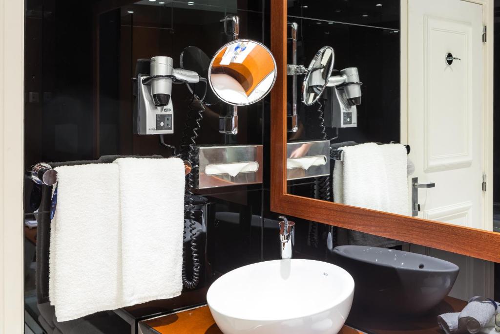 um banheiro com uma pia e um espelho em Radisson Blu Hotel Lisbon em Lisboa