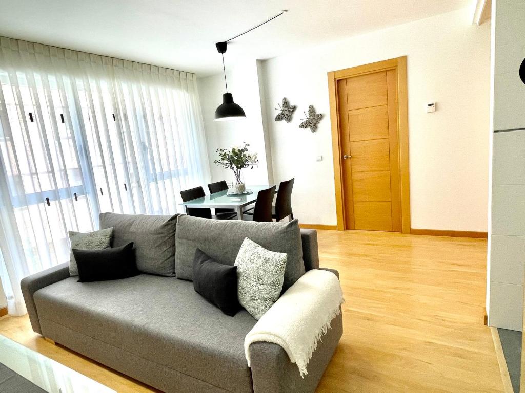 Sala de estar con sofá gris y mesa en Apartamento Pinares en Soria