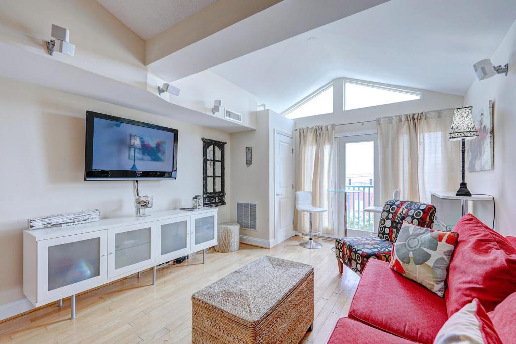 ein Wohnzimmer mit einem roten Sofa und einem Flachbild-TV in der Unterkunft Town of Dewey Beach -- The Opal #306S in Dewey Beach