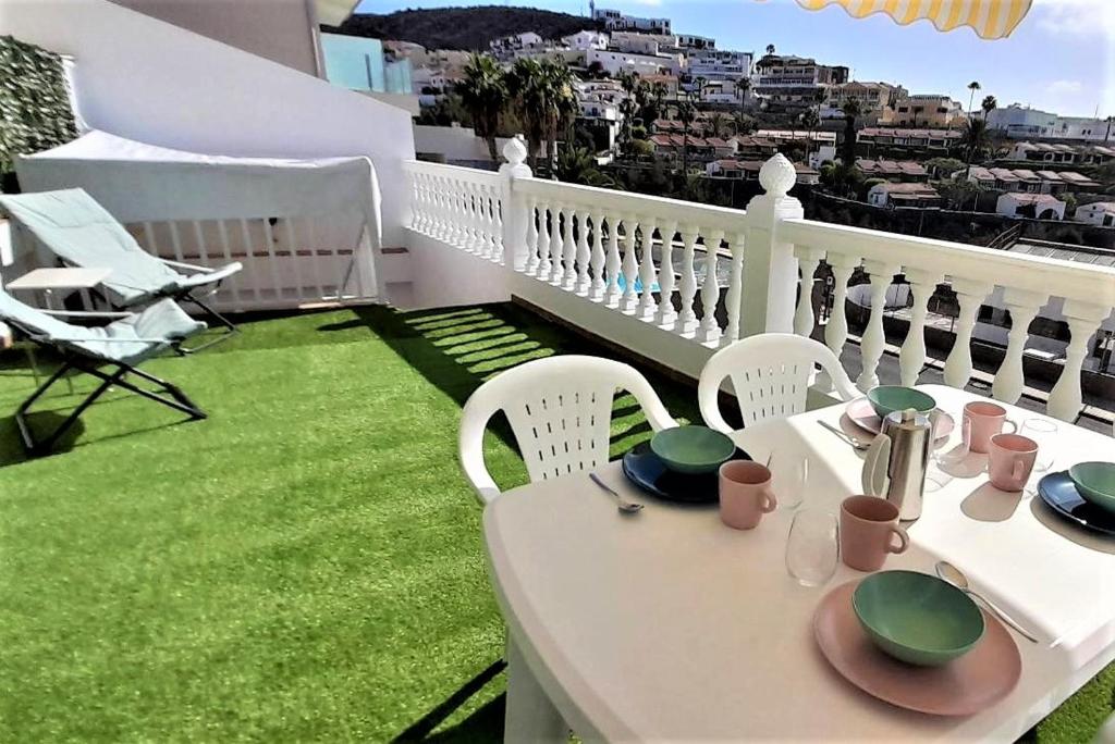een witte tafel en stoelen op een balkon bij Comfy Apartment with WiFi and Free Parking in Arguineguín