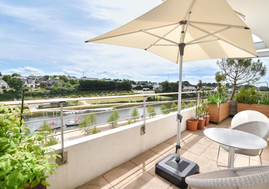 a balcony with a table and an umbrella at Un Appartement PENTHOUSE d'Exception sur le Port de Vannes in Vannes