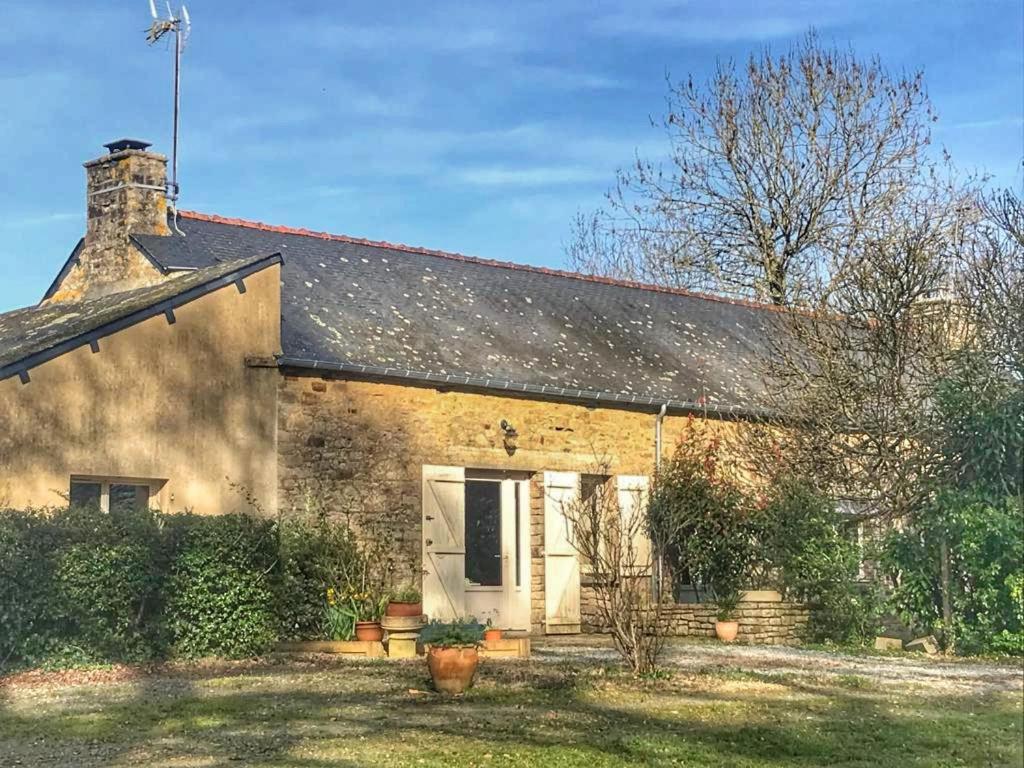 een oud stenen huis met een witte deur bij Logement de charme calme assuré in Rieux