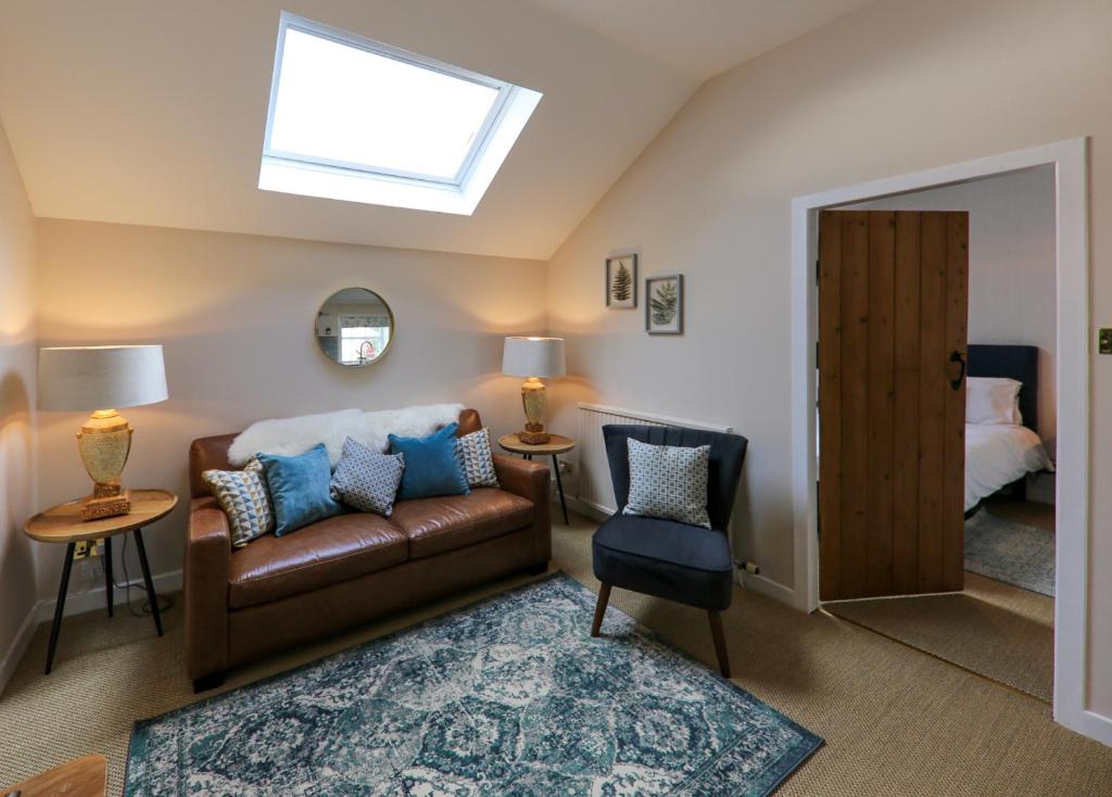a living room with a couch and a bed at Postbox Cottage in Melrose