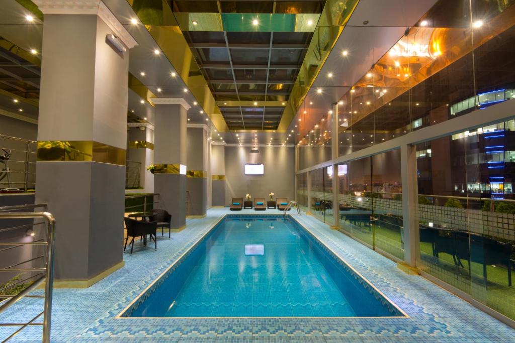 a swimming pool in a building with a restaurant at Luxury Inkari Hotel in Lima