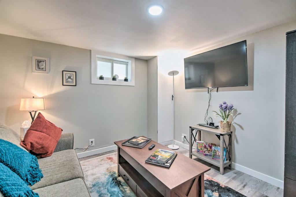 a living room with a couch and a table at Fresh Downtown Longmont Apartment - Walk to Main! in Longmont
