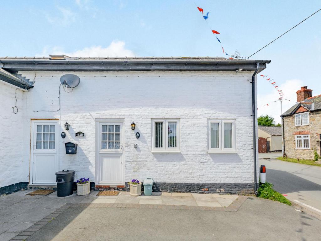un bâtiment blanc avec une porte dans une rue dans l'établissement Yew Tree Cottage, à Welshpool