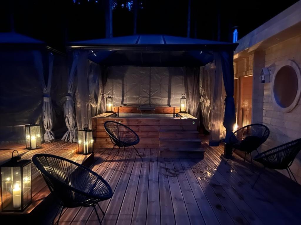 a patio with chairs and lights at night at EVASION gîtes et spa in Saint-Léonard