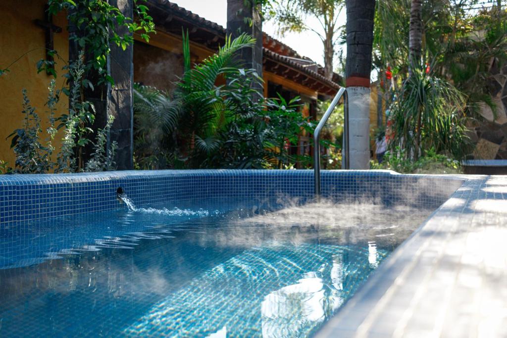 a swimming pool with a fountain in a house at Las Jaras Aguas Termales in La Garita