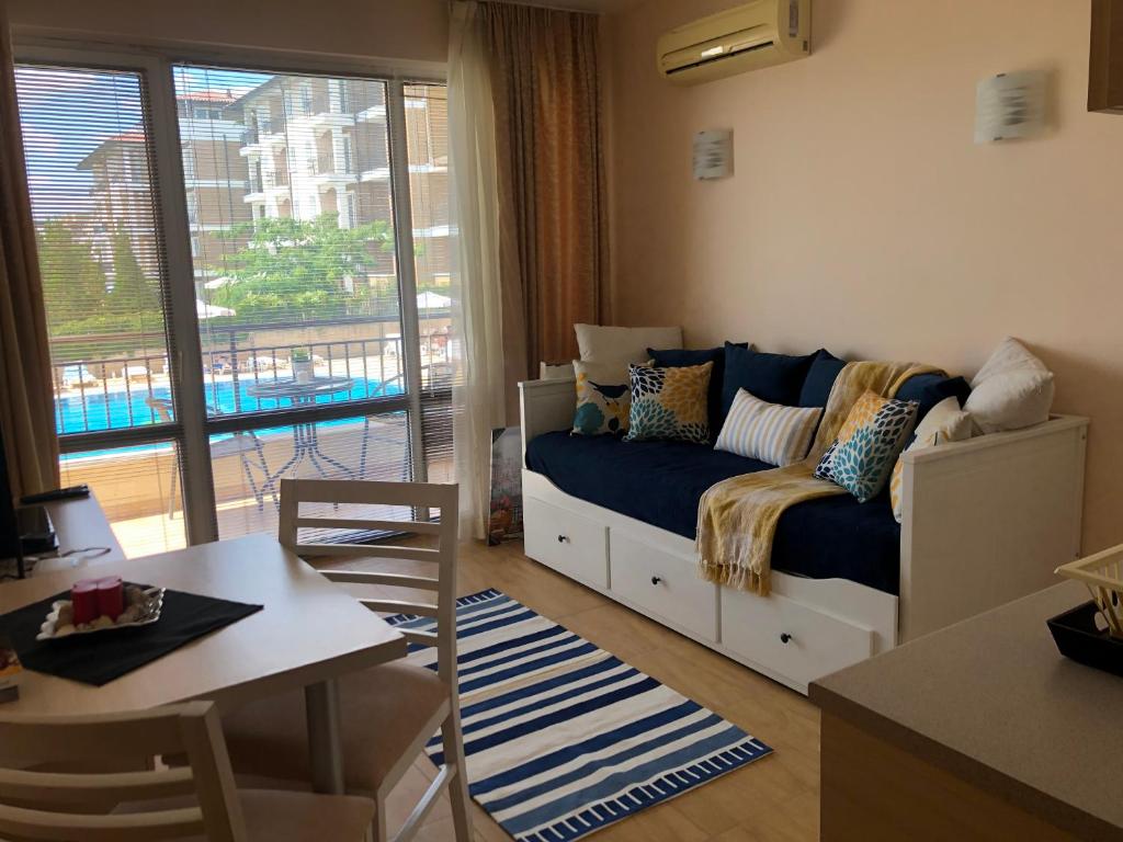 a small living room with a couch and a balcony at Apart Hotel Aqua Dreams in Sveti Vlas
