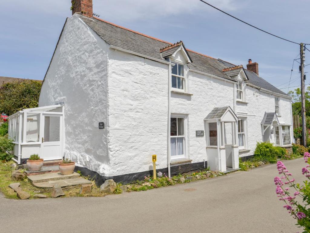 a white house with white windows on a street at Agar Cottage in Port Isaac