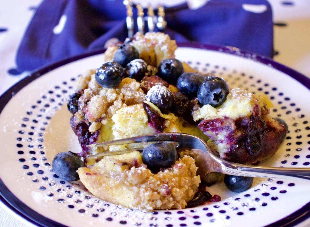 a plate of food with a fork and blueberries at The Butler House Bed & Breakfast in Niagara Falls