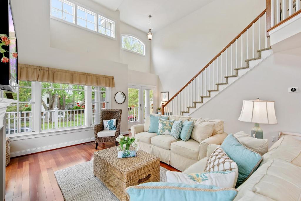a living room with white furniture and a staircase at Bethany West -- 719 Fenwood in Bethany Beach