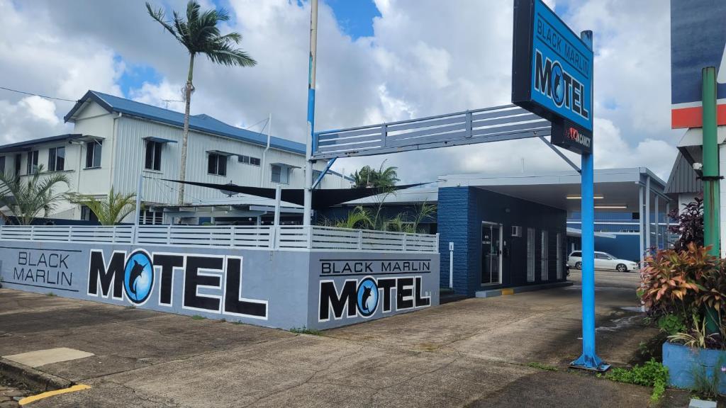 una señal de motel de metal negro frente a un edificio en Black Marlin Motel en Innisfail