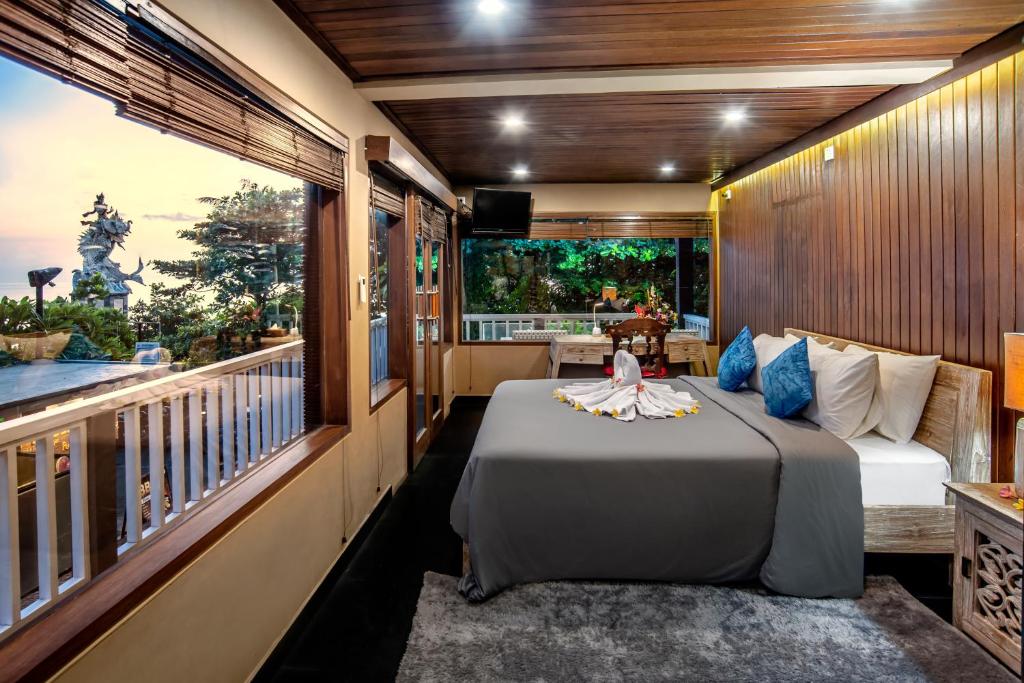 a bedroom with a bed and a balcony at PNB Beach Resort in Canggu
