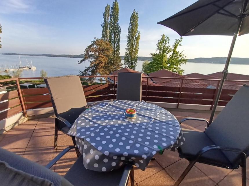 einen Tisch und Stühle mit einem Polka-Punkt-Tisch und einem Sonnenschirm in der Unterkunft BodenSEE Apartment Überlingen Strandweg in Überlingen