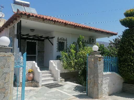 a small white house with a blue fence and stairs at Ferienhaus Athens Marmor Garden in Kalívia Thorikoú