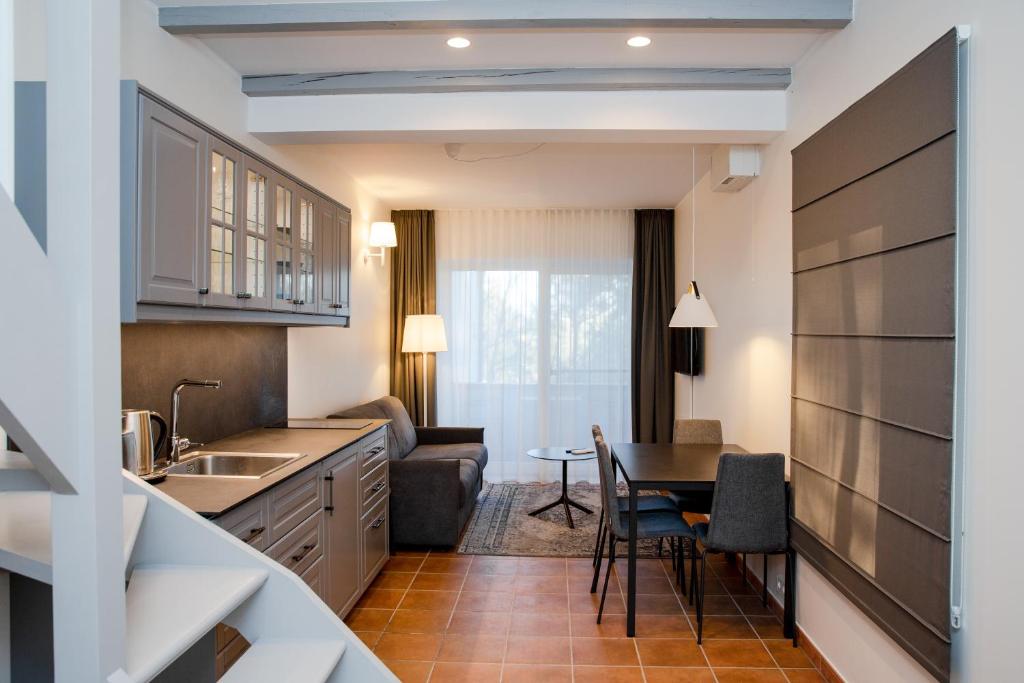 a kitchen with a table and a dining room at Dvi Nidos in Nida