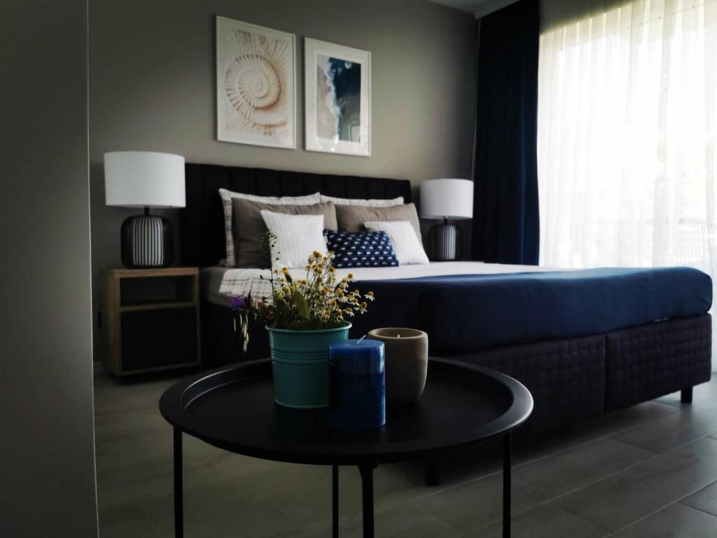 ein Schlafzimmer mit einem Bett und einem Tisch mit einem blauen Sofa in der Unterkunft Blue Breeze in Sinemorets