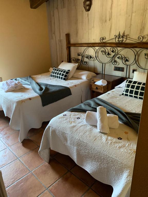 1 dormitorio con 2 camas y ropa de cama blanca en Hotel Rural Vistahermosa en Béjar