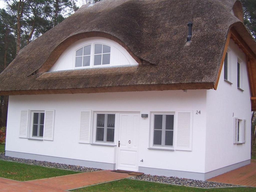 a white cottage with a thatched roof at Weißes Traumhaus in Glowe