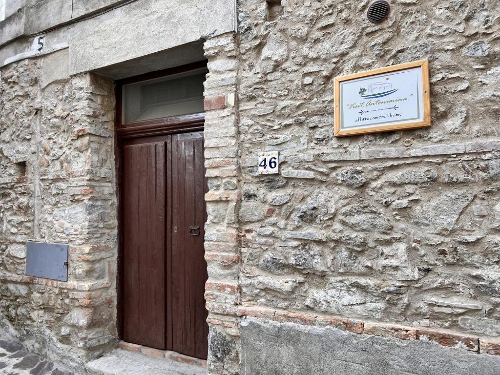 un edificio de piedra con una puerta y un cartel en él en Visit.Antonimina | home, en Antonimina