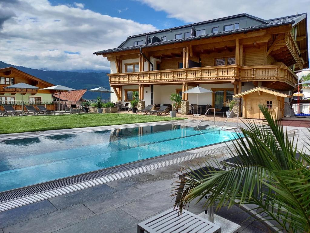 a house with a swimming pool in front of a building at Pension Edelweiß in Sankt Johann im Pongau