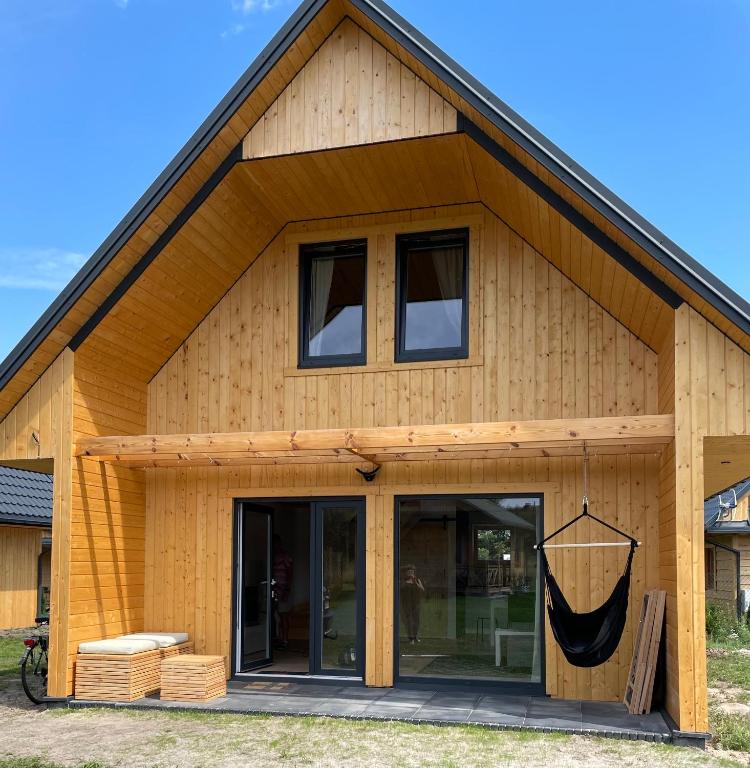 a wooden house with a large glass door at Domki Rózin in Zwierzyniec