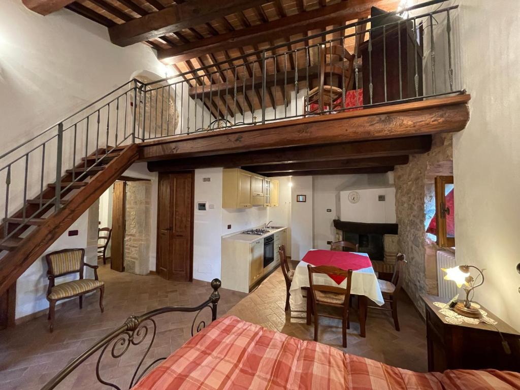 een slaapkamer met een trap en een keuken met een tafel bij Agriturismo Antico Castagno in Montebibico