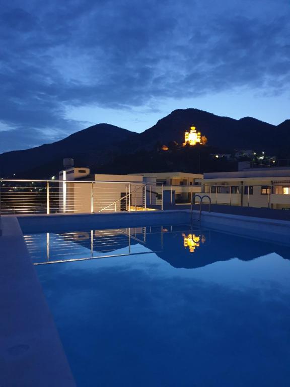 una piscina por la noche con una montaña en el fondo en Impressive apartment en Trebinje