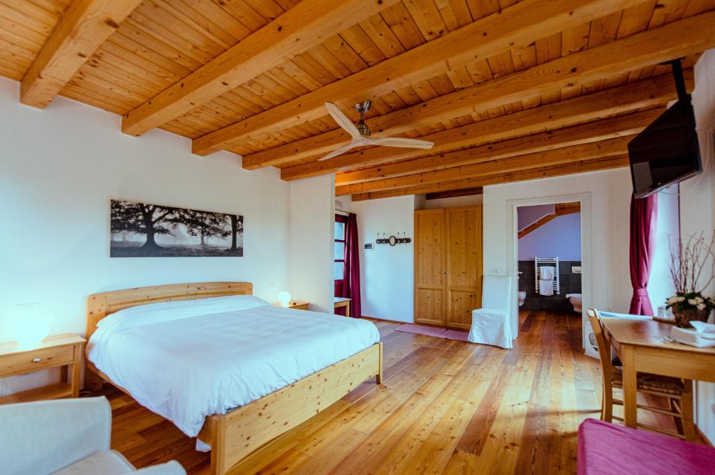 - une chambre avec un lit et un plafond en bois dans l'établissement Agriturismo Ronchi Rò, à Lonzano