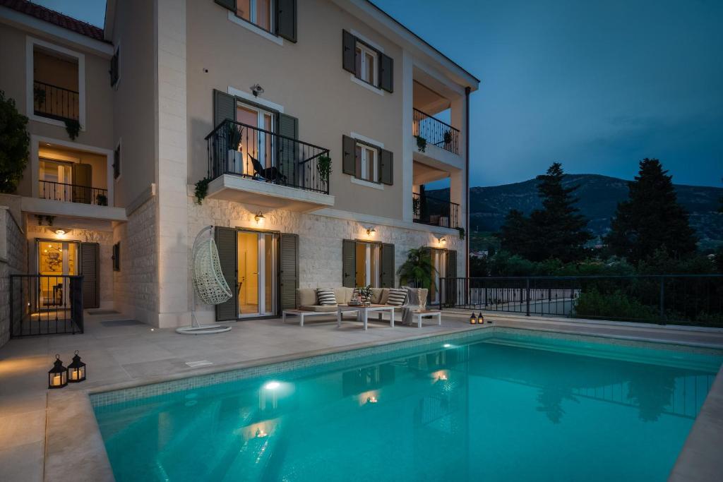 a villa with a swimming pool in front of a building at Villa Mirta in Bol