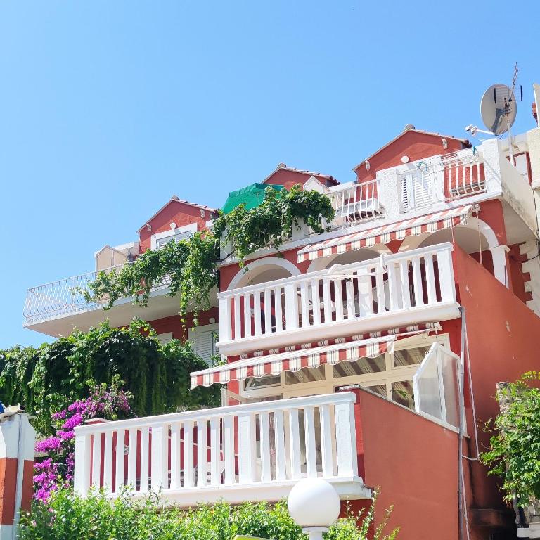 an apartment building with white balconies and flowers at Villa Kipre in Cavtat
