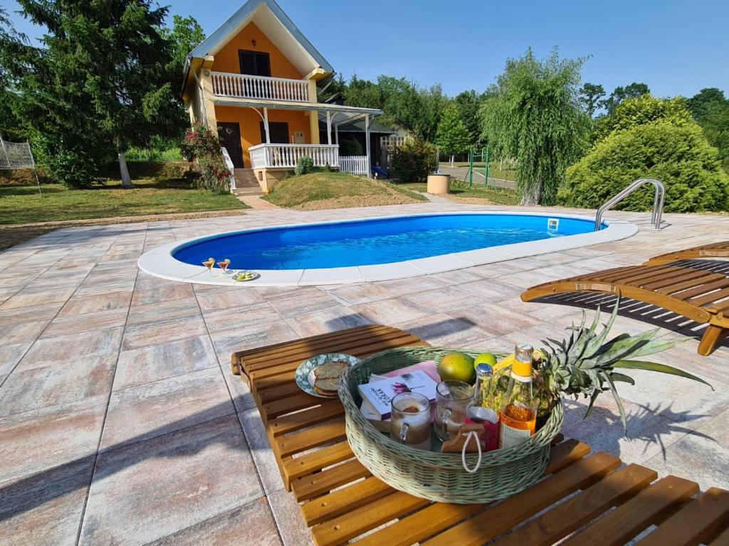 a basket of food sitting on a bench next to a pool at Croatia Cottage in Nova Kapela