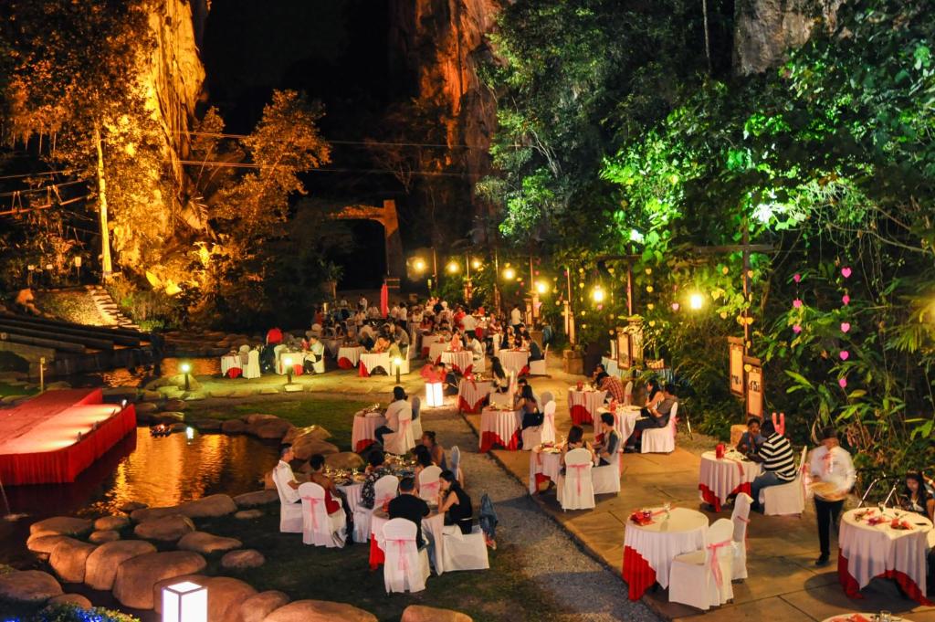 un gruppo di persone sedute ai tavoli in una grotta di notte di Sunway Lost World Hotel a Ipoh