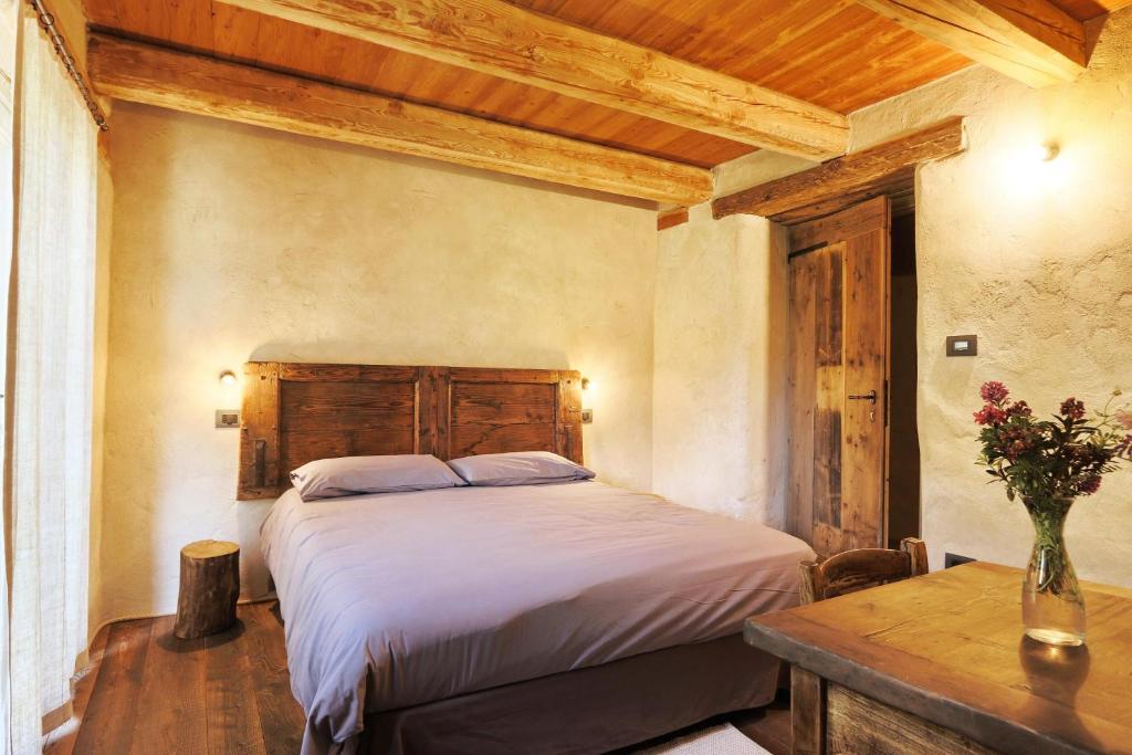 a bedroom with a large bed and a table at Locanda Al Torch - Ristorante e Camere in Stroppo